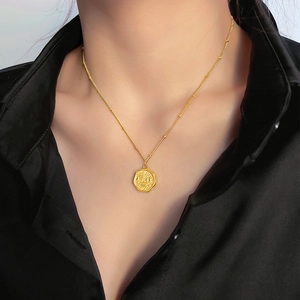 Collana a catena con ciondolo a fiore di pesco placcato oro su una camicia nera