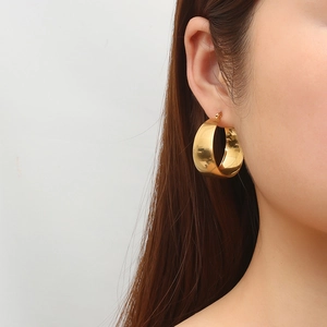 French vintage wide hoop earrings in polished gold titanium steel on female model