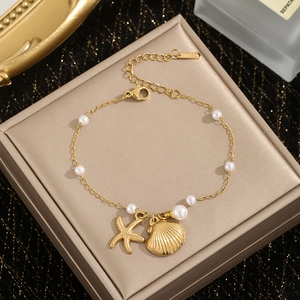 Gold stainless steel starfish and shell pearl necklace displayed on a jewelry box