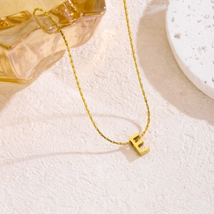 Nahaufnahme der goldenen Edelstahlkette mit einem minimalistischen Buchstaben-E-Anhänger