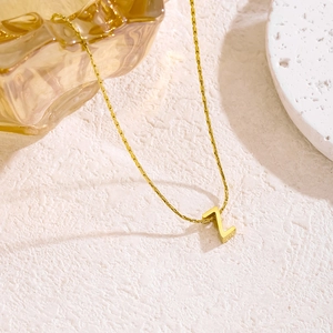 Detail der goldenen Buchstabe Z Halskette auf einer flachen Schlangenkette mit Schatten