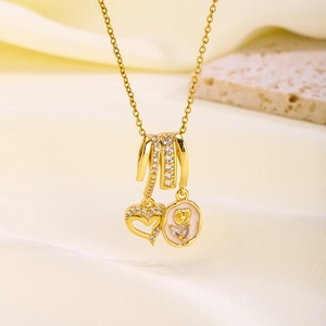 Detail of gold-plated pendant with sparkling zircon heart and rose medal on stone