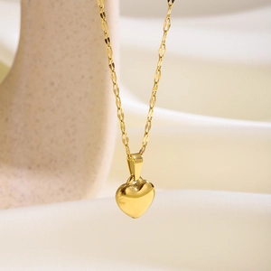 Vista macro de un collar con colgante de corazón dorado pulido en un expositor