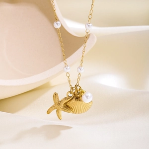 Gold starfish and shell necklace with white pearls on elegant white satin backdrop