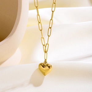 Detalle de un collar con colgante de corazón dorado y cadena de eslabones rectangulares