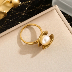 Macro detail of 18k gold starfish shell ring with a large white pearl inlay