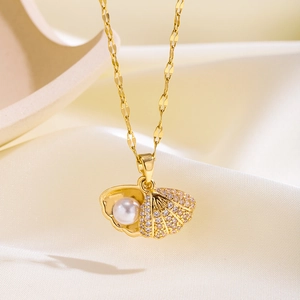 Macro detail of 18k gold plated shell pendant with white pearl and sparkling zircons