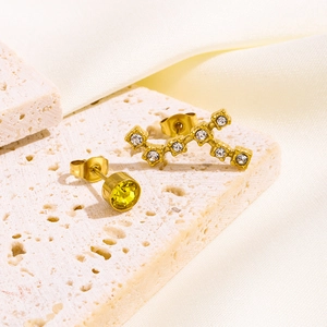 Detailansicht asymmetrischer Goldohrstecker mit gelbem Edelstein und weißen Zirkonia