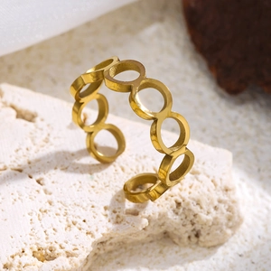 Nahaufnahme eines hohlen, kreisförmigen, 18K vergoldeten Edelstahlrings auf Stein
