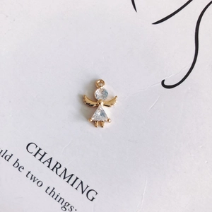 Detail of angel pendant with gold copper finish and zircon inlay on a white card