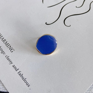 Gros plan d'un accessoire de boucle d'oreille géométrique irrégulier en émail bleu