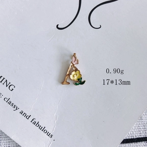 Makroaufnahme von goldfarbenem Buchstabe A Anhänger mit rosa Schmetterling und Blume