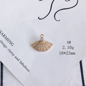 Macro shot of 18x23mm fan-shaped gold pendant with cubic zirconia for DIY jewelry