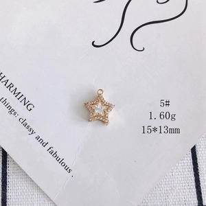 Macro shot of 18k gold plated star pendant with cubic zirconia on white display card