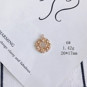Macro shot of 20mm gold-plated sunburst charm pendant with sparkling white zircons