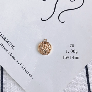 Detail view of 14K gold plated floral hollow charm with cubic zirconia accents