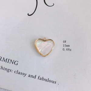 Vue macro d'un pendentif cœur en nacre de 15mm avec monture dorée pour la création de bijoux