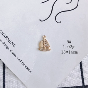 Detail view of 18k gold plated sailboat pendant with micro-pave zircons and 18x14mm dimensions