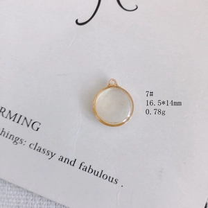 Détail d'un pendentif rond en nacre à bord doré de 16,5x14mm pour la création de bijoux
