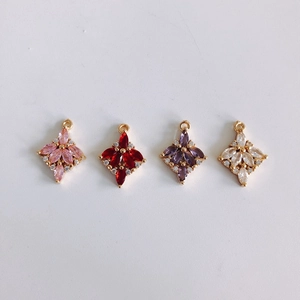 Dettaglio di ciondoli a fiore in rame placcato oro con zirconi colorati per gioielli fai da te