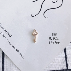 Detailed macro shot of a gold-plated key pendant with cubic zirconia for DIY jewelry