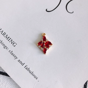 Dettaglio di un ciondolo a stella con zircone rosso e base dorata per gioielli DIY