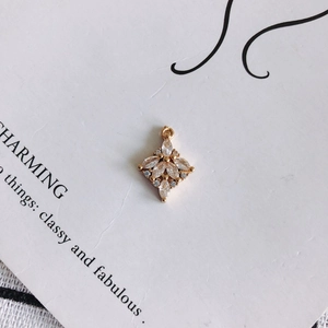 Dettaglio macro di un ciondolo floreale in zircone per gioielli fai-da-te con base oro