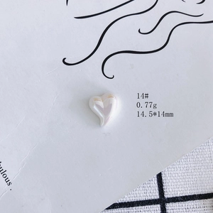 Macro shot of a heart-shaped resin accessory with iridescent pearl finish, 14.5x14mm