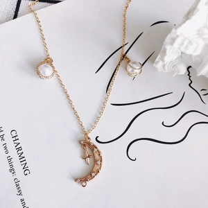 Élégant collier lune et étoile doré orné de perles blanches et d'incrustations de zircon