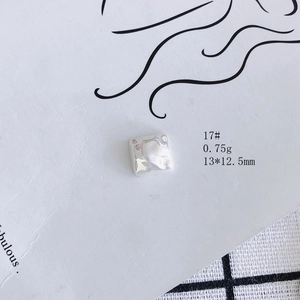 Macro detail of square silver hammered metal charm with dimensions 13x12.5mm and 0.75g weight