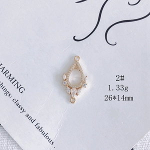 Vue macro d'un connecteur de bijoux doré en forme de goutte avec zircons brillants