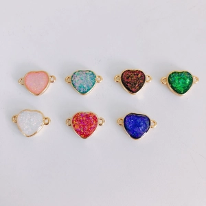 Macro shot of colorful resin heart charms with gold-edged frames for DIY jewelry making