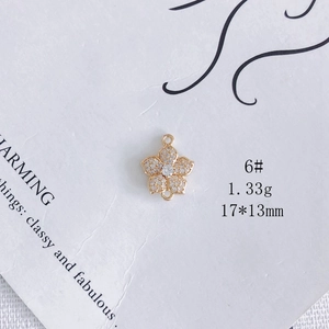 Détail macro d'un connecteur fleur doré avec zircons blancs et boucles de connexion