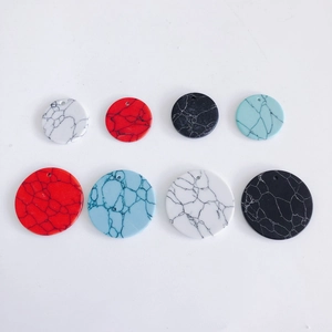 Flat lay of colorful marble textured acrylic round charms with holes for DIY jewelry