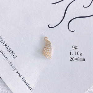 Détail macro d'un pendentif feuille plaqué or 18k avec zircone et dimensions 20x8mm