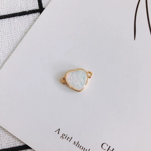 Detailed view of heart resin charm with gold edges and dual loops for DIY jewelry making