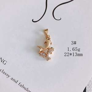 Detail of a 1.65g gold-plated copper double fish pendant with sparkling white cubic zirconia