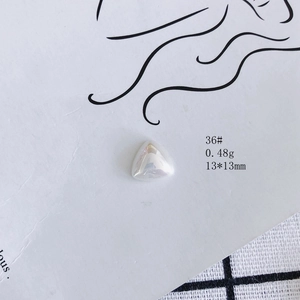 Macro detail of aurora triangle resin charm measuring 13x13mm with iridescent luster