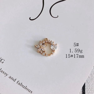 Macro shot of gold-plated heart floral charm with cubic zirconia inlay, 15x17mm size