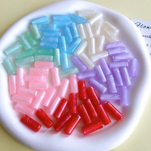 Dettaglio macro di perle cilindriche in resina marmorizzata per la creazione di gioielli DIY