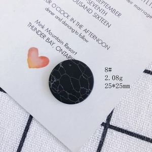 Macro detail of a 25mm round acrylic pendant with black and white marble texture