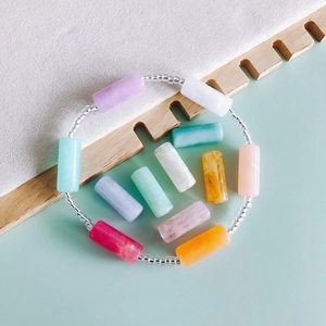 Perle cilindriche in resina macaron colorate su bracciale con texture marmorea