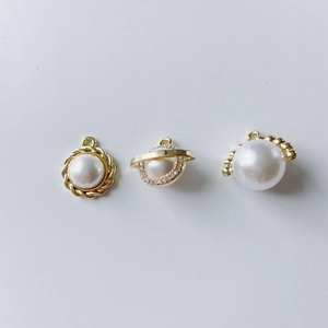 Detailed macro view of three gold-plated pearl charms with rhinestone DIY jewelry parts
