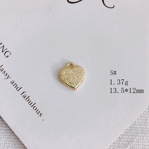 Vista macro di un ciondolo a cuore dorato 13,5x12mm con incisione I love you e bordo perlato