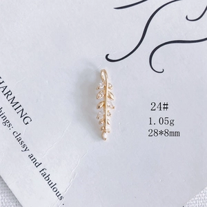 Vue macro d'un pendentif feuille doré avec zircon serti montrant les détails 28x8mm