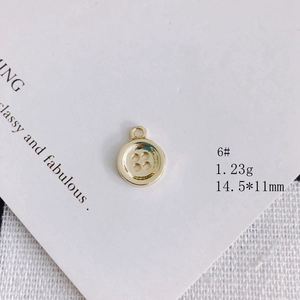 Macro di un ciondolo dorato a forma di bottone da 14,5 mm per gioielli fai-da-te su carta