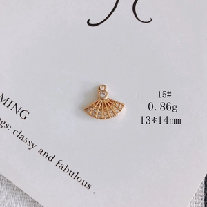 Macro detail of a 13x14mm fan-shaped gold pendant with zircon inlay for jewelry DIY