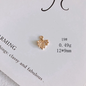 Close-up of a gold maple leaf pendant with cubic zirconia inlay, 12x9mm charm for DIY jewelry