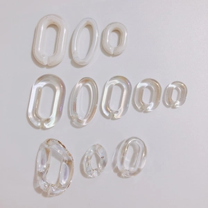 Detail of multi-size creamy white and iridescent acrylic oval open jump rings for DIY jewelry