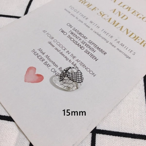 Vue macro de breloque ronde en résine 15mm avec dentelle noire sur carte de vœux